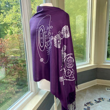 Load image into Gallery viewer, Psyche & Lucy Asteroid Missions Scarf (purple with silver asteroid and spaceraft illustrations) draped on a mannequin with a background of windows and greenery outside.