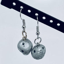 Load image into Gallery viewer, Asteroid Dangle Clay Earrings shown hanging from the diagtonal black bar of an earring display
