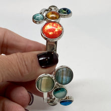 Load image into Gallery viewer, Solar Hand holding Adjustable Bracelet vertically with giant planets and Pluto at bottom, and Sun and inner planets at top.