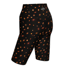Load image into Gallery viewer, Digital mock-up of fitted shorts, black with small red and orange images of planet-forming disks at various angles.