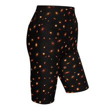 Load image into Gallery viewer, Digital mock-up of fitted shorts, black with small red and orange images of planet-forming disks at various angles.