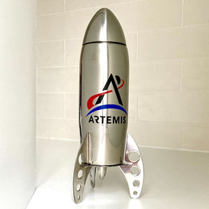 Stainless stell rocket-shaped cocktail shaker with the Artemis logo on a white tile background