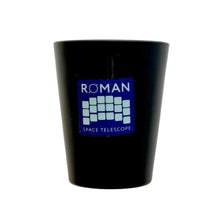 Load image into Gallery viewer, A black shot glass featuring a blue and white 'ROMAN SPACE TELESCOPE' logo on the front, set against a plain light gray background.