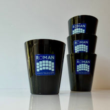 Load image into Gallery viewer, Four glossy black Roman Space Telescope shot glasses, with one standing at front and three stacked, on a white reflective surface against a white background.