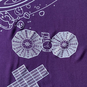 illustration detail of the Lucy spacecraft and surrounding details in silver ink on a purple plush-weave scarf