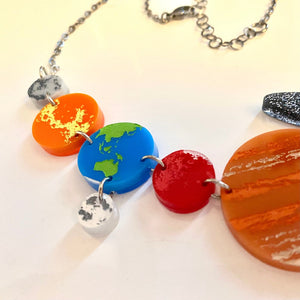 Detail of Solar System statement necklace showing Mercury, Venus, Earth, Moon, Mars, Jupiter, and some of Saturn's rings