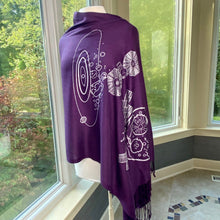 Load image into Gallery viewer, Psyche &amp; Lucy Asteroid Missions Scarf (purple with silver asteroid and spaceraft illustrations) draped on a mannequin with a background of windows and greenery outside.