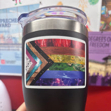 Load image into Gallery viewer, Space pride progress-pride-design vinyl decal on a black and silver travel mug with a clear plastic top
