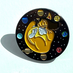 Cat-purr-nicur round enamel pin with an orange cartoon cat holding the Sun surrounded by planets on a black space background