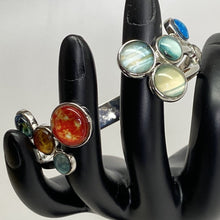 Load image into Gallery viewer, Mannequin hand  holding Solar System Cluster Adjustable Cuff Bracelet, with Sun and inner planets on left side of gap and giant planets and Pluto on right side of gap.