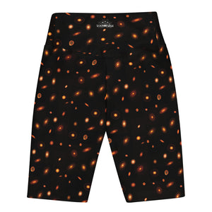 Digital mock-up of the back of fitted shorts, black with small red and orange images of planet-forming disks at various angles. 
