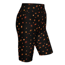 Load image into Gallery viewer, Digital mock-up of fitted shorts, black with small red and orange images of planet-forming disks at various angles. 