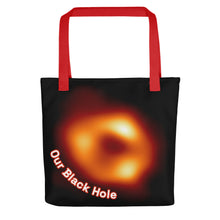 Load image into Gallery viewer, Digital mock up of a black tote bag with red handle printed with the Event Horizon Telescope image of the Sgr A* supermassive black hole in the Milky Way Galaxy with curved text reading &quot;Our Black Hole&quot; in red and white on one side.