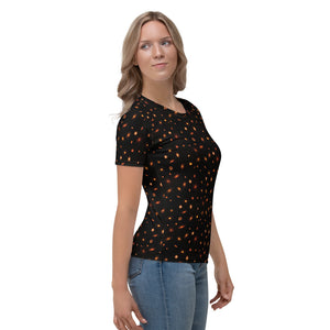 Digital mock-up front of t-shirt on model, round neck and short sleeves, black with small red and orange images of planet-forming disks at various angles. 