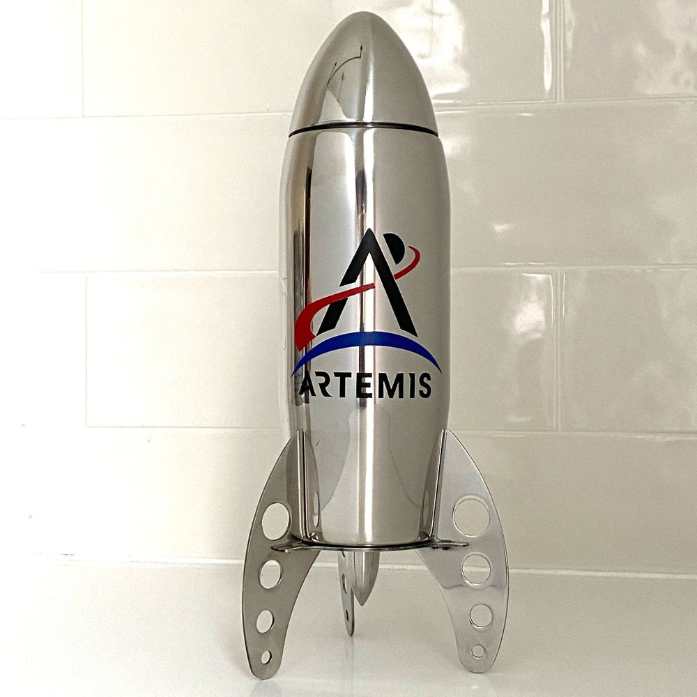 Stainless stell rocket-shaped cocktail shaker with the Artemis logo on a white tile background