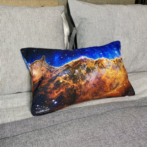 JWST Cosmic Cliffs of the Carina Nebula throw pillow on gray bedding with wood plank background